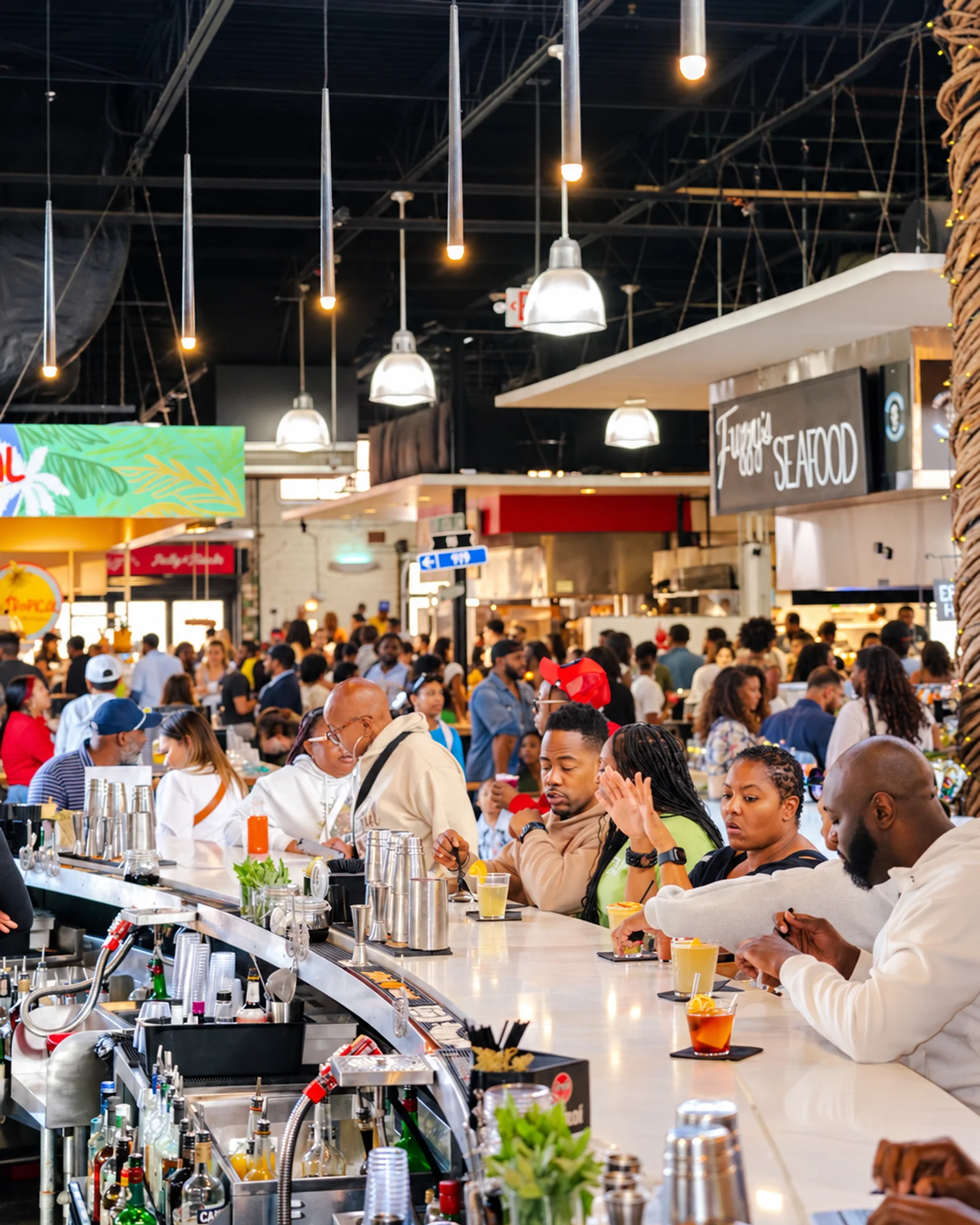Guests sharing food and drinks around the communal bar