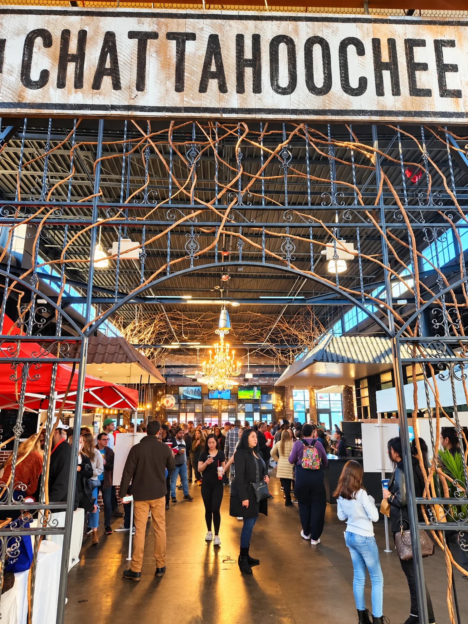 Guests walking through the vine-covered gate under the Chattahoochee sign into the food hall