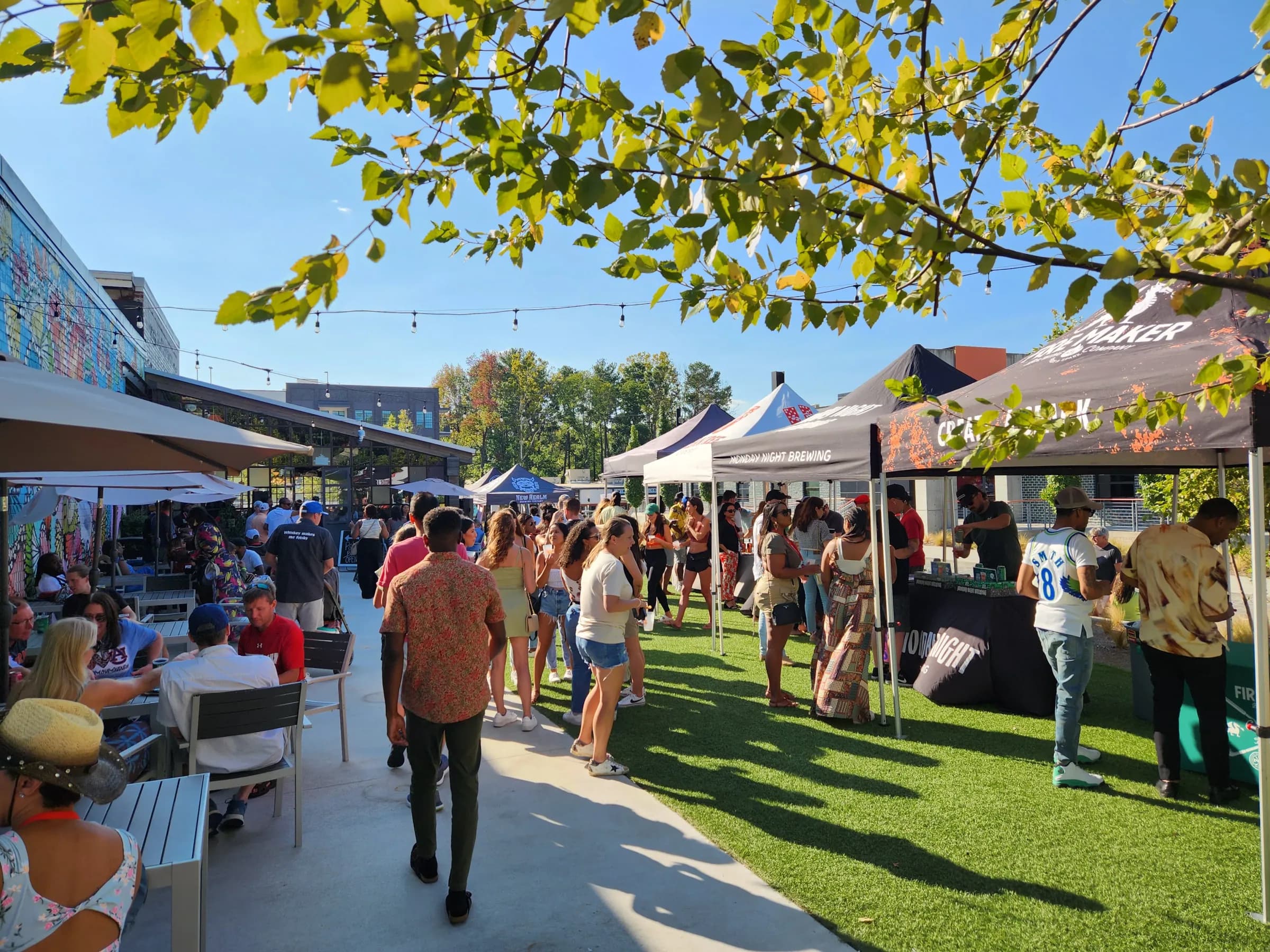 Guests mingling at an outdoor patio event with brewery tents