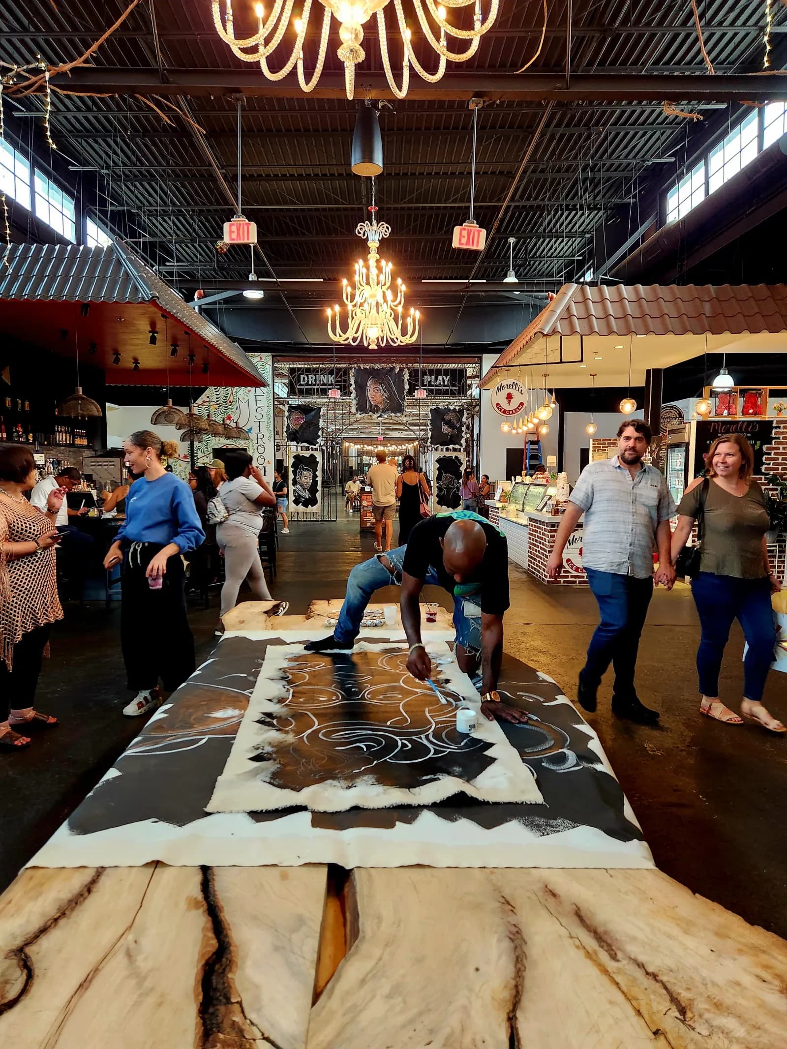 A live artist painting inside the food hall as guests watch